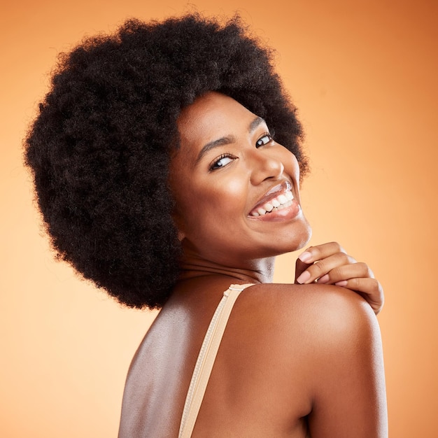 Kosmetyki do pielęgnacji skóry i czarna kobieta z uśmiechem, która jest szczęśliwa, pewna siebie i brązowym tłem studyjnym do pielęgnacji ciała lub odważna dla naturalnego piękna Makijaż kobiecej gładkiej skóry lub dziewczyny afro dla dobrego samopoczucia