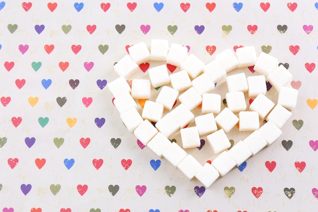 Kostki cukru w kształcie serca na tle papieru