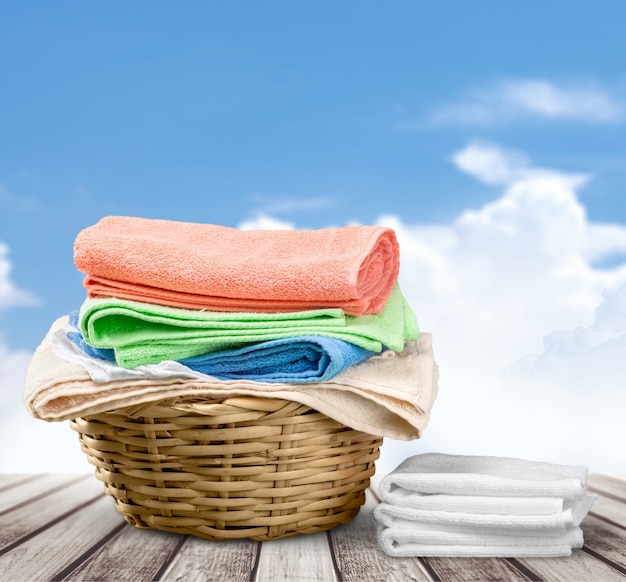 Kosz na pranie z kolorowymi ręcznikami na tle