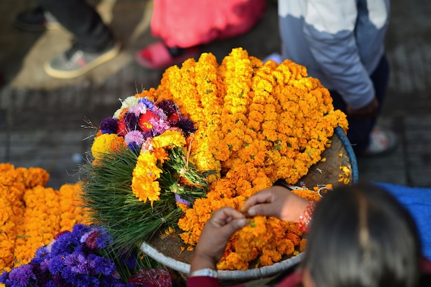 Zdjęcie kosz z naszyjnikami kwiatów pomarańczowych nagietka na rynku placu w nepalu selektywne fokus