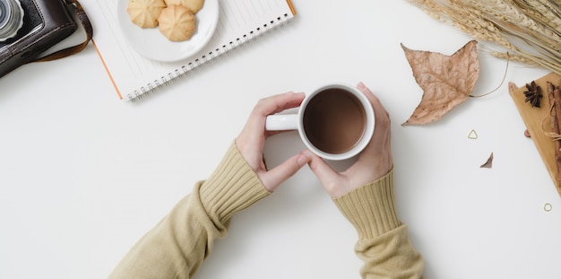 Koszt Stały Strzał Trzyma Gorącą Kakaową Filiżankę W Jesieni Workspace Z Kopii Przestrzenią Kobieta