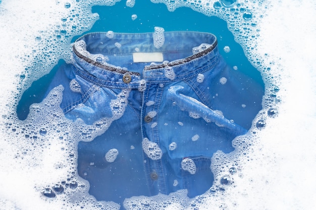 Koszula Jean Zanurzona W Wodzie Z Detergentem W Proszku. Koncepcja Prania