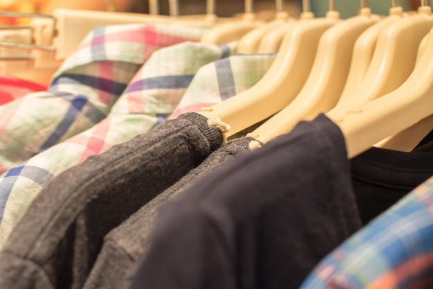 Koszule i kurtki wiszące na wieszakach w sklepie