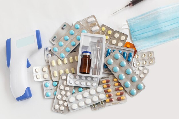 Koszyk pełen tabletek i materiałów medycznych na jasnoszarym tle