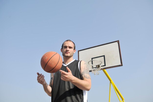 koszykarz ćwiczący i pozujący do koncepcji koszykówki i sportowca