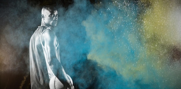 Zdjęcie koszykarz przed rozpryskiwaniem kolorowego proszku