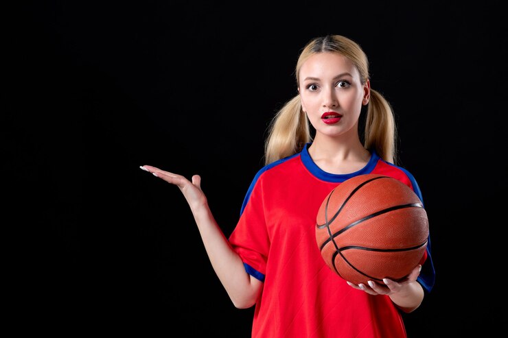 Zdjęcie koszykarz w sportowych ubraniach z piłką na czarnym tle gra sportowiec gra