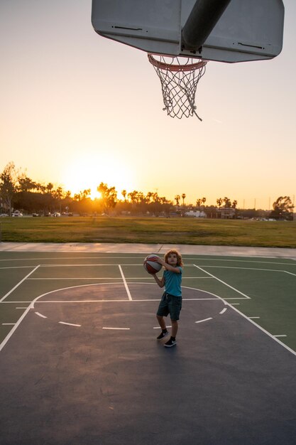 Koszykówka chłopiec gra treningowa na zachód słońca