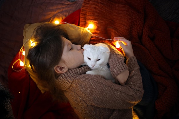 Zdjęcie kot i dziewczyna śpią razem pod choinką atmosferą koncepcji bożego narodzenia i nowego roku