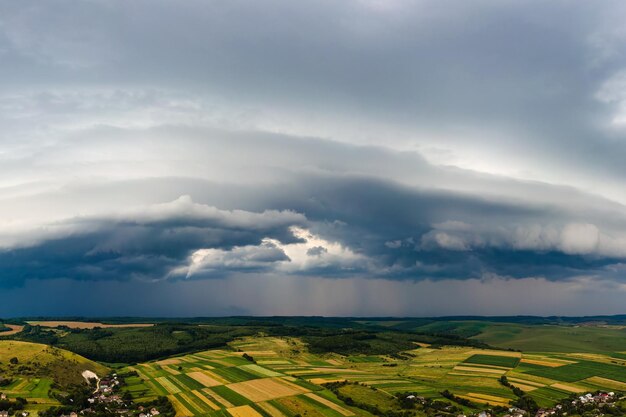 Krajobraz ciemnych chmur tworzących się na burzliwym niebie podczas burzy nad obszarami wiejskimi.