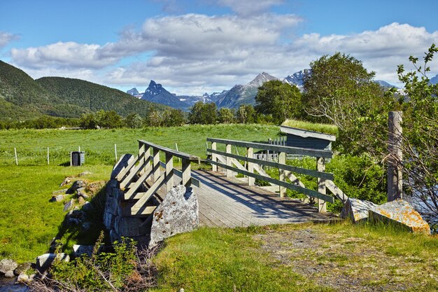 Zdjęcie krajobraz drewnianego mostu w odległej zielonej okolicy bodo w nordland norwegia infrastruktura i zbudowane przejście na ekołące i polach środowiskowych toursim i odkrywanie przyrody w ciągu dnia