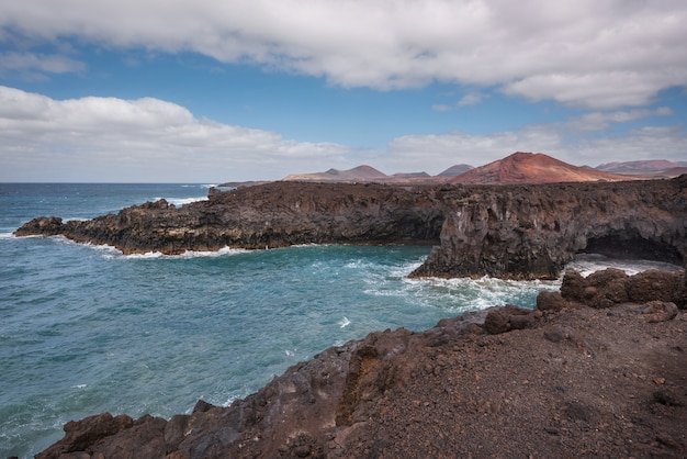 Krajobraz Lanzarote. Linia brzegowa Los Hervideros, jaskinie lawowe, klify i falisty ocean.