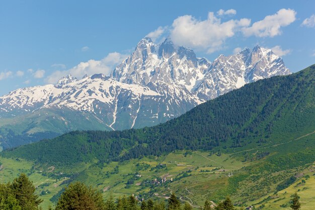 Zdjęcie krajobraz lato i ośnieżone szczyty górskie w pobliżu wsi mestia, gruzja