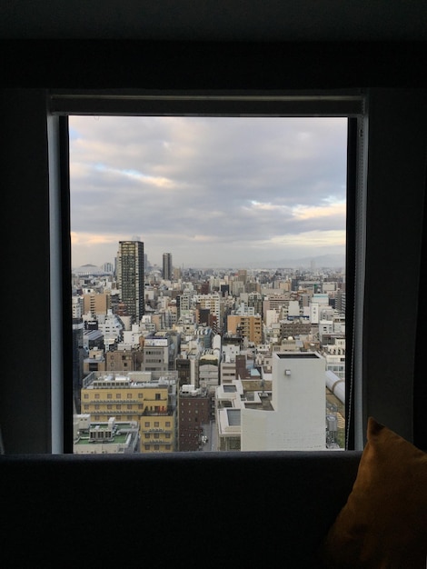 Zdjęcie krajobraz miasta na tle nieba widziany przez okno