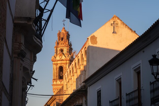 Krajobraz miasta z wieżą kościelną o zachodzie słońca w Ecija Sewilla Andaluzja Hiszpania