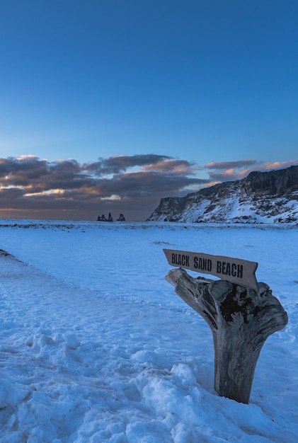 Krajobraz plaży i drewniany znak złotego światła wschodu słońca na plaży Black Sand Beach