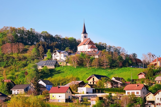 Krajobraz z domami na zielonych wzgórzach w pobliżu Zgornja Kungota w Słowenii. Malowniczy krajobraz i przyroda w pobliżu Mariboru w Słowenii. Unikalna turystyka.