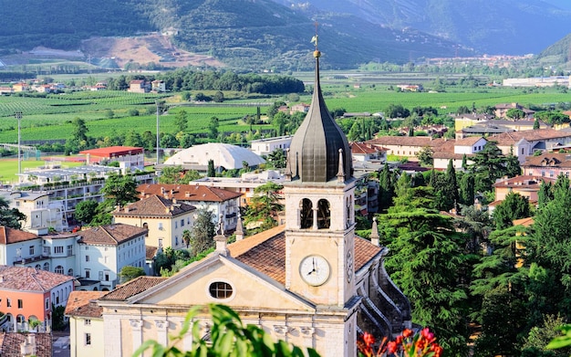 Krajobraz z kościołem Santa Maria Assunta na skale w dolinie Sarca w pobliżu jeziora Garda w Trentino we Włoszech. Krajobraz z katedrą na górze miasta Arco w Trento w pobliżu Riva del Garda