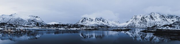 Krajobraz z pięknym zimowym jeziorem i ośnieżonymi górami na Lofotach w północnej Norwegii. Widok panoramiczny