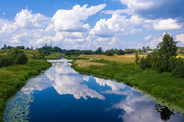 Zdjęcie krajobraz z pięknymi chmurami kumulus odbijającymi się w rzece teza w regionie iwanovo w letni dzień