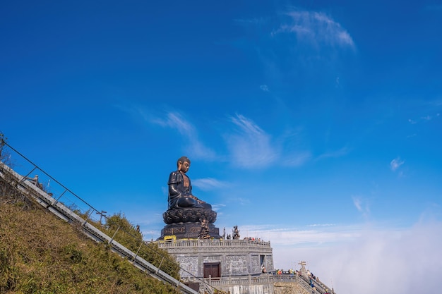 Krajobraz z posągiem Wielkiego Buddy na szczycie góry Fansipan Sapa region Lao Cai Wietnam Posąg Buddy Amitabha na szczycie Fansipan na dachu Indochin