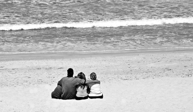 Krajobraz z rodziną siedzącą na monochromatycznej plaży