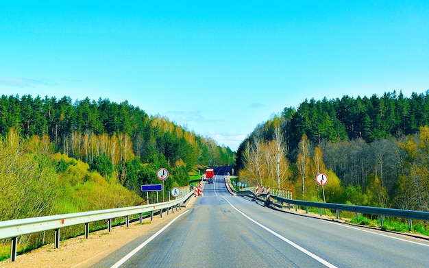 Krajobraz z samochodem i mostem w drodze na Litwie. Wakacyjna podróż autostradą z naturą. Sceneria z napędem na wakacyjną podróż