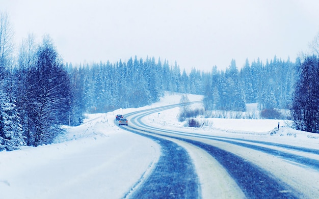 Krajobraz z samochodem w śnieżnej drodze w Finlandii. Wakacyjna podróż autostradą z naturą. Sceneria z zimową jazdą na wakacyjną podróż do rekreacji. Jazda ruchowa w Europie. Transport na podjeździe.
