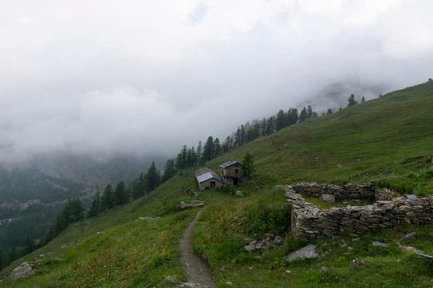 Krajobrazowy widok na Alpy. Szczyty pokryte są chmurami i mgłą z powodu sztormowej pogody.