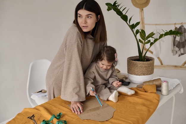 Krawcowa szyje ubrania w swoim studio z córką