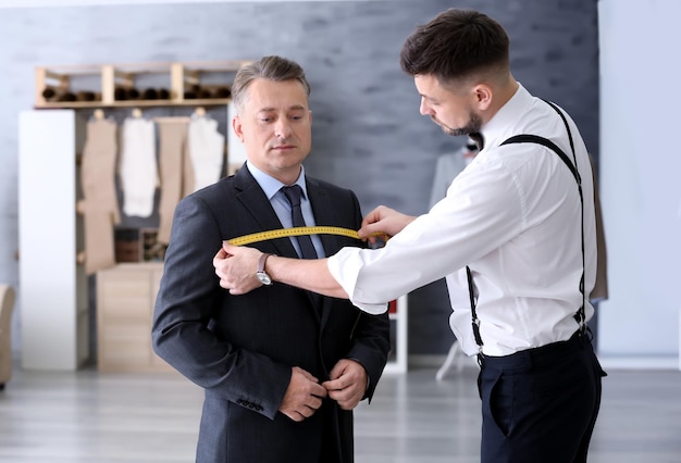 Krawiec mierzący męskie wymiary w atelier