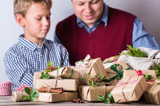 Kreatywna koncepcja świąteczna zero waste ojciec i syn pakujący prezenty