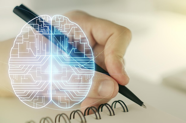 Kreatywna koncepcja sztucznej inteligencji z hologramem ludzkiego mózgu i ręką człowieka piszącą w notatniku na tle