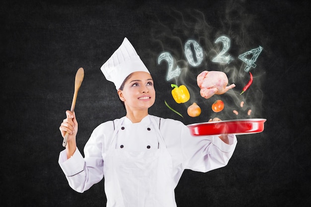 Kreatywna szefowa kuchni kobieta gotuje na smażeniu z magią i dymem w kształcie numeru 2016 nowy rok