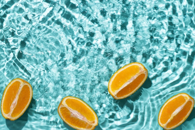 Kreatywne letnie tło z pomarańczowymi plasterkami owoców w wodzie w basenie Letnia tapeta z miejsca na kopię