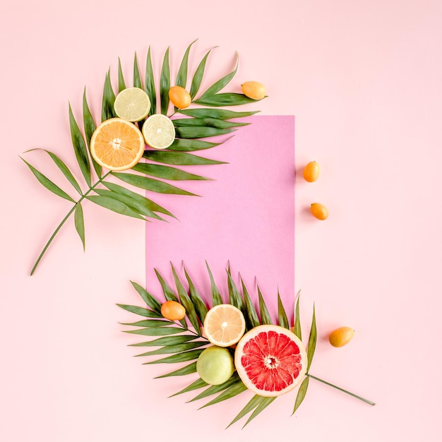 Kreatywny układ wykonany z papieru i letnich owoców tropikalnych na różowym tle koncepcja jedzenia płaska leżała to