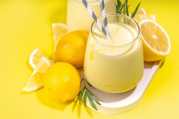 Kremowy cytrynowy koktajl owocowy jogurt ar koktajl mleczny Kwaśny słodki napój ze świeżymi cytrynami na białym żółtym tle kopia przestrzeń