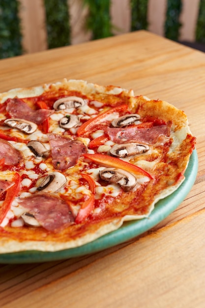 krepa w stylu pizzy z salami, pieczarkami, pomidorem na drewnianym stole