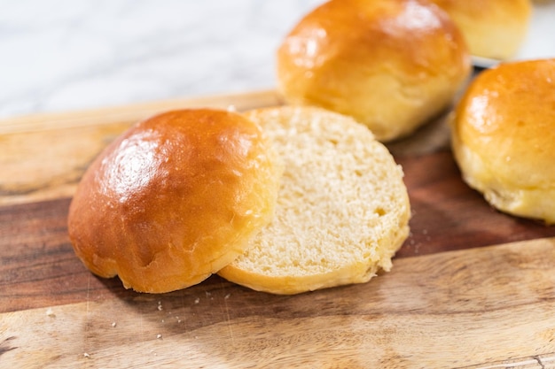 Krojenie świeżo upieczonej bułki brioche na desce do krojenia.