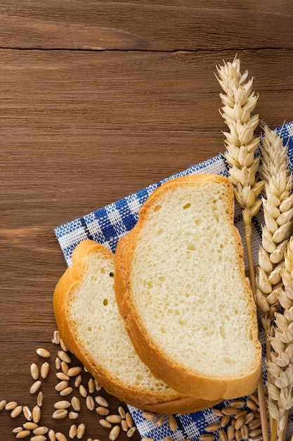 Krojony chleb i kłosy pszenicy na serwetce