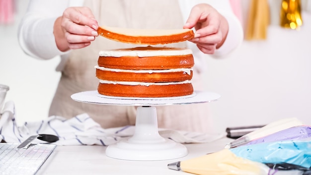 Zdjęcie krok po kroku. cukiernik robi tort jednorożca na przyjęcie urodzinowe małej dziewczynki.