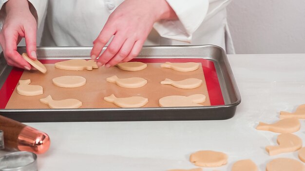 Krok po kroku. Niewypieczone wielkanocne ciasteczka cukrowe ułożone do pieczenia na blasze do pieczenia.