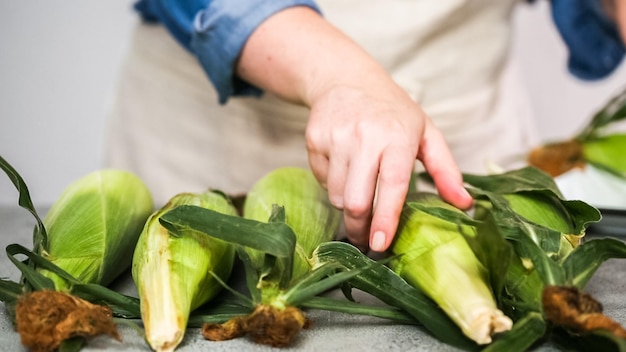 Krok po kroku. Obieranie kukurydzy organicznej na meksykańską kukurydzę w kolbach Elote.