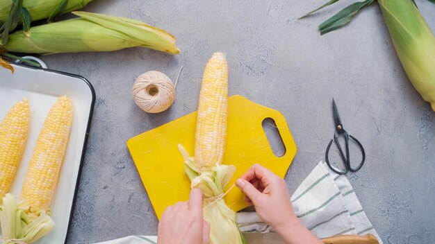 Krok po kroku. Obieranie kukurydzy organicznej na meksykańską kukurydzę w kolbach Elote.