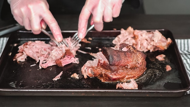 Krok po kroku. Szatkowanie pieczonej łopatki wieprzowej za pomocą dwóch widelców.