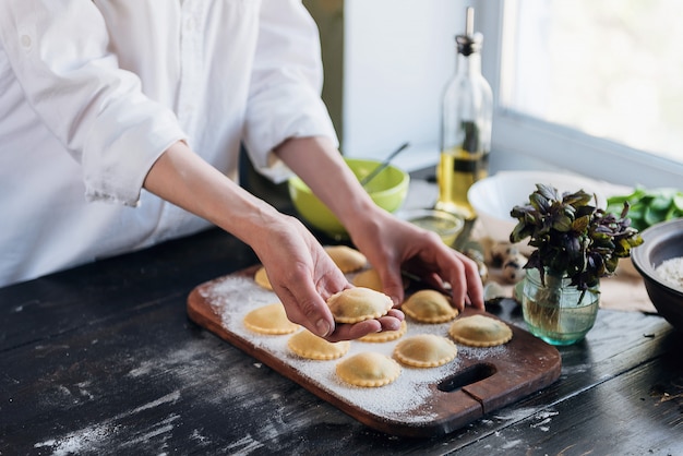 Krok po kroku szef kuchni przygotowuje ravioli z serem ricotta, żółtkami przepiórczymi i szpinakiem z przyprawami. Szef kuchni przygotowuje się do ravioli