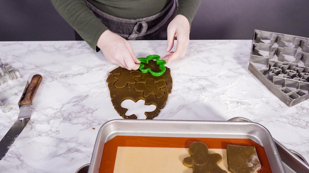 Krok po kroku. Wycinanie kształtów świąteczną foremką do ciastek z piernikowego ciasta.