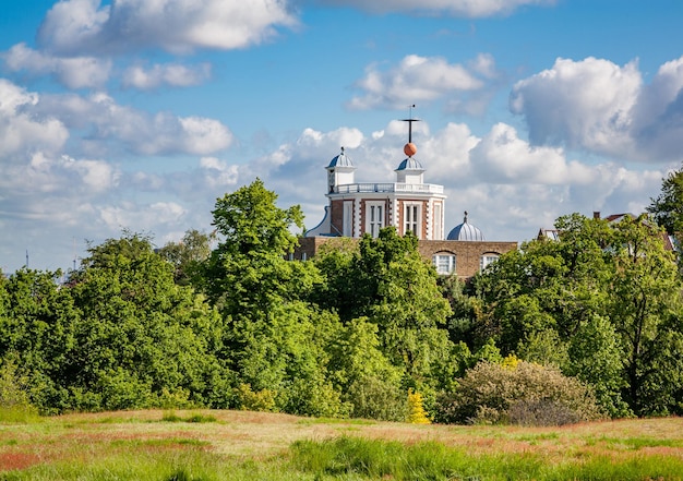 Zdjęcie królewskie obserwatorium na wzgórzu pod chmurnym niebem w greenwich londyn anglia