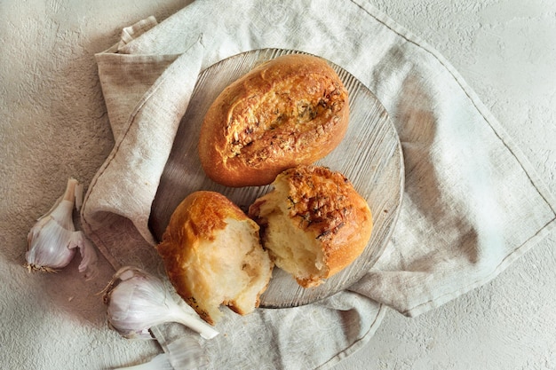 Kromki chleba czosnkowego na okrągłej drewnianej desce na stole