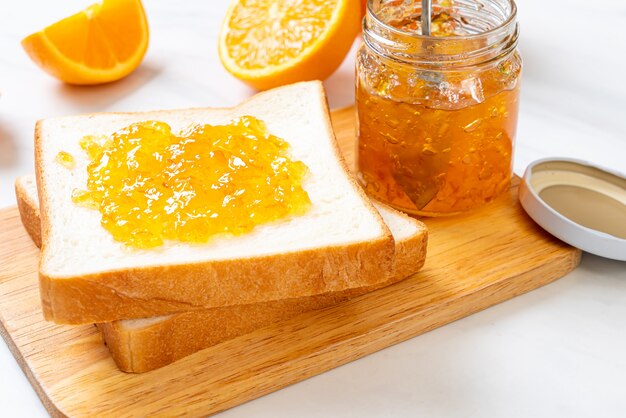 Kromki chleba z dżemem pomarańczowym